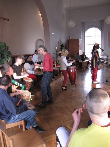 Aïdara Seck und seine Musikerfreunde geben den Rhythmus vor.Die eintreffenden Trommelworkshopteilnehmer gehen zu den bereitstehenden Trommeln und verstärken mit ihrem Trommeln den Klang.
