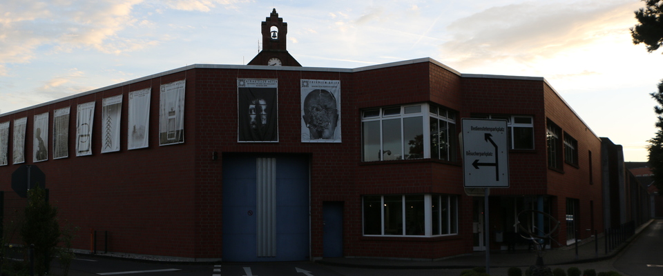 An der Außenmauer und der Außenpforte sind weithin sichtbar für die Öffentlichkeit einige der Banner der Ausstellung "Frei Räume" zu sehen. Über dem Tor der Außenpforte hängen die Banner des Professor  Zbigniew Bajek und der Professorin Dr. Ulrika Eller-Rüter.