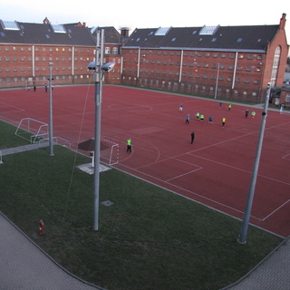 Aus den Fenstern der Abteilung 11 in Haus 2 ist der Sportplatz und im Hintergrund Haus 1 mit dem sogenannten B-Flügel und C-Flügel zu sehen.