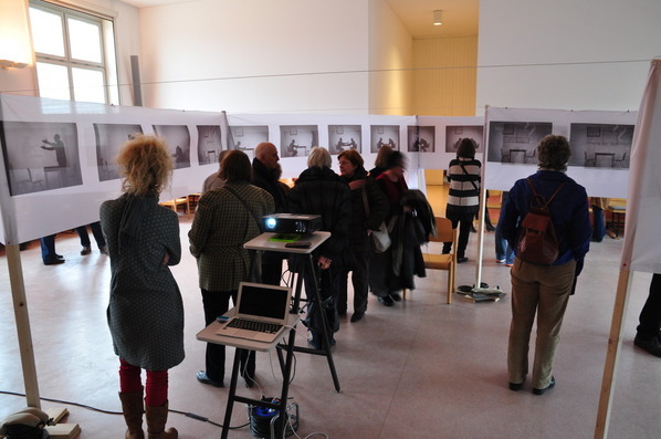 Besucher der Ausstellung diskutieren und unterhalten sich über die Bilder der Fotoausstellung. 