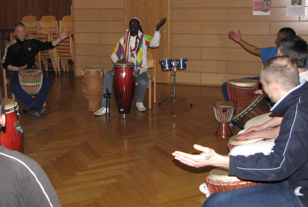 Percussionist und Sänger Aïdara Seck mit den Teilnehmern des Trommelworkshops.