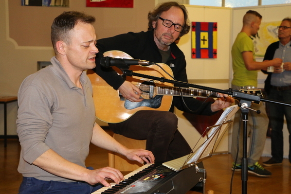 Inhaftierte und Uwe Claus singen und musizieren gemeinsam für das Publikum der Vernissage. 