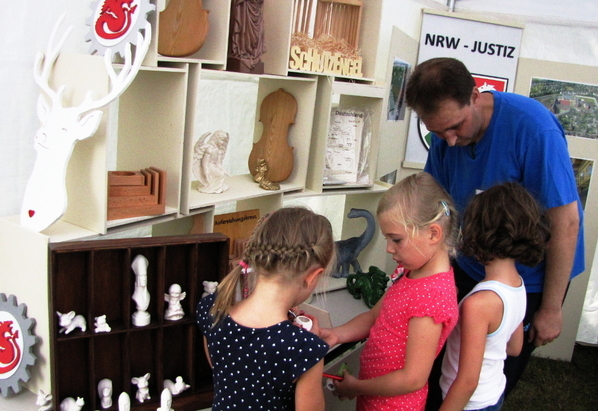 Kleine Tonfiguren aus der Arbeitstherapie Ton konnten ebenfalls bemalt werden. Im Bild einer der Gefangenen im Gespräch mit Kindern.