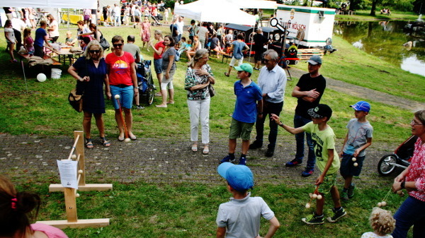 Zwei Holzkugel verbunden mit einem kurzen Seil werden geworfen um über einer der drei Holzstangen des Gestells liegen zu bleiben. Je nach dem werden so ein, zwei oder drei Punkte vom jeweiligen Spieler erreicht. Bis 21 Punkte wird gespielt, kommt ein Spieler über diese Punktzahl fängt er wieder bei Null an. Dies ist aber nur eine Spielvariante. Kinder und Erwachsene hatten sichtlich viel Spaß an den drei mitgebrachten Spielen gefertigt von der Arbeitstherapie Holz.