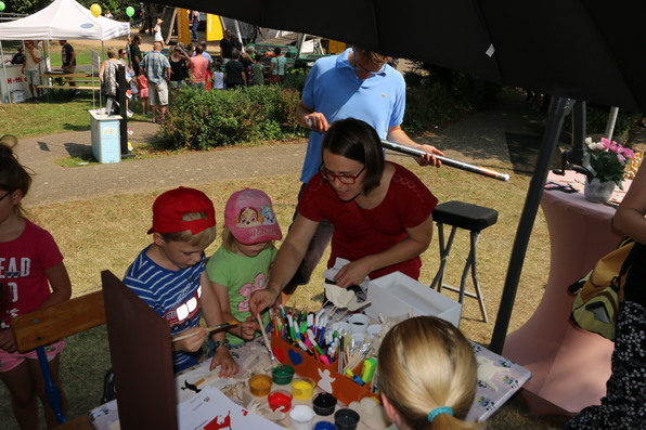 Kinder bemalen ihre Kunstwerke.