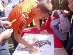 Lukas Podolski gibt Autogramme für die Inhaftierten
