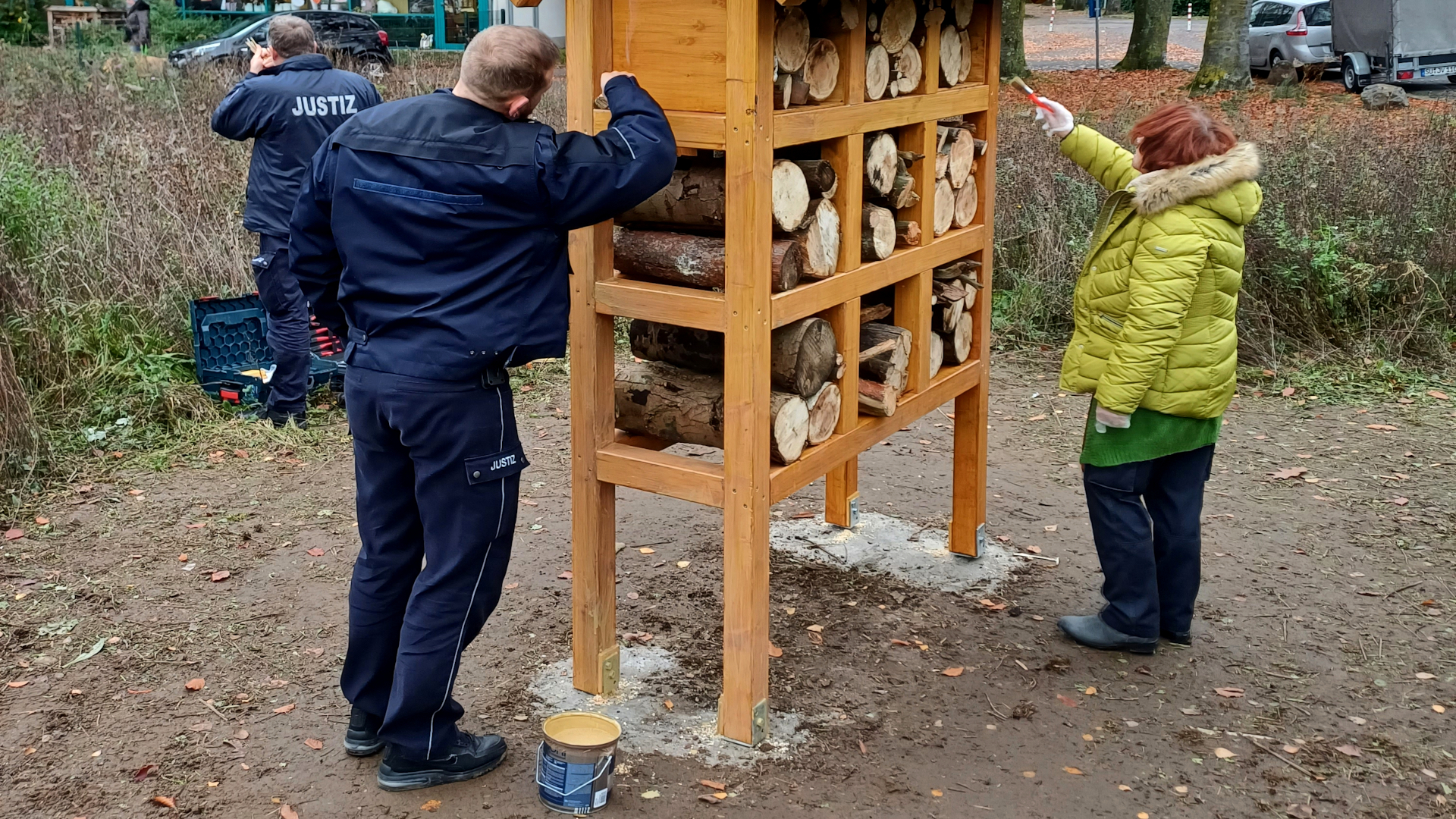 Frau Reisinger und Herr Nonn streichen das Insektenhotel mit Holzschutz nach.